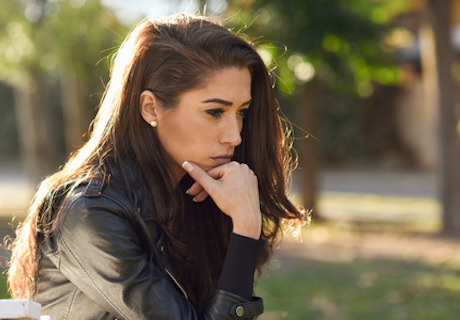 51805008 - thoughtful woman sitting alone outdoors. girl worried in an urban park